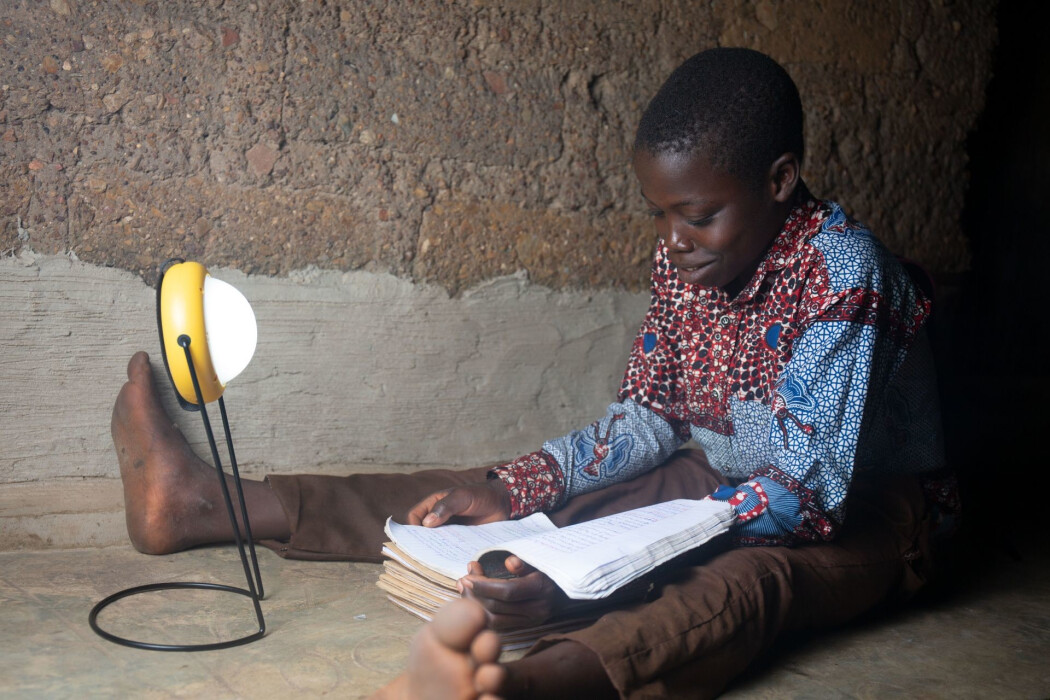 Enfant étudiant avec une lampe solaire de Mivo Energie au Togo