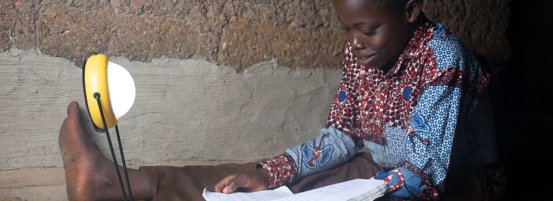 Enfant étudiant avec une lampe solaire de Mivo Energie au Togo