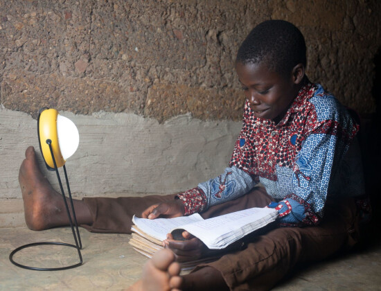 Enfant étudiant avec une lampe solaire de Mivo Energie au Togo
