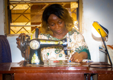 Couturière utilisant une lampe solaire Mivo Energie