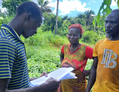 un animateur de wakili rend visite à un couple d'agriculteurs sur leur parcelle