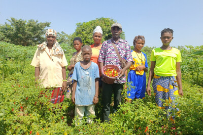 des agriculteurs accompagnés par wakili posent dans un champ avec leur récolte