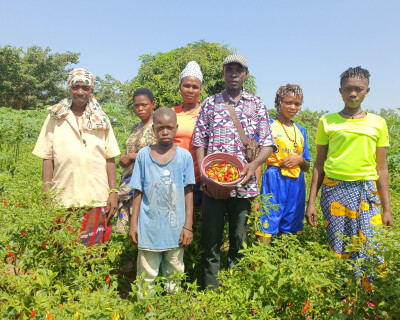 des agriculteurs accompagnés par wakili posent dans un champ avec leur récolte