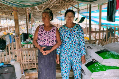 deux commerçantes de Sont Oo Tehtwin posent devant le lieu où elles stockent leurs marchandises