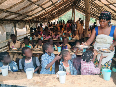 Femmes en Guinée servant un repas aux enfants dans le cadre des cantines scolaires de Wakili