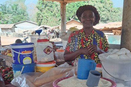 portrait d'une bénéficiaire de wakili devant son étal en extérieur