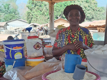 portrait d'une bénéficiaire de wakili devant son étal en extérieur