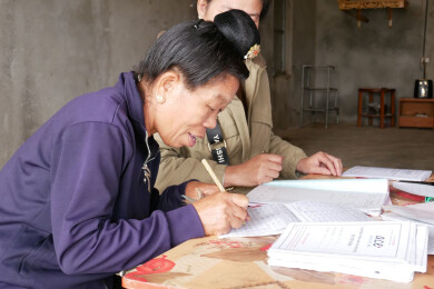 une beneficiaire d'anh chi em au vietnam, signe pour l'octroi d'un nouveau crédit