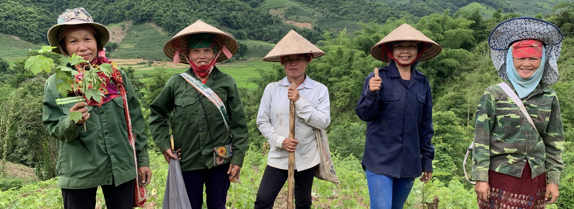4 agricultrices vietnamiennes et une formatrice du programme Anh Chi Em sont dans une plantation de