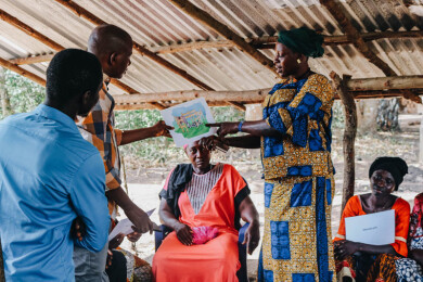Une femme présente un support de formation à des participantes lors d'une formation du programme Wa