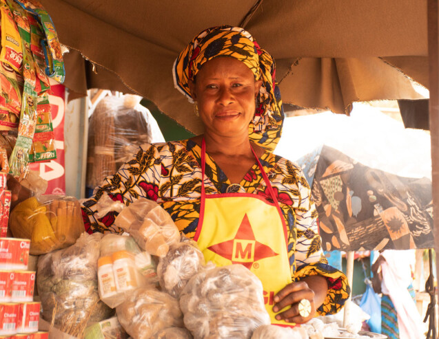 A female trader, supported by Entrepreneurs du Monde, in front of her food stall