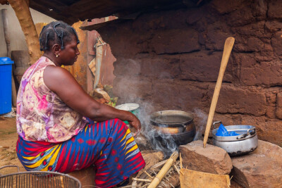 Femme cuisinant au milieu des fumées au Togo