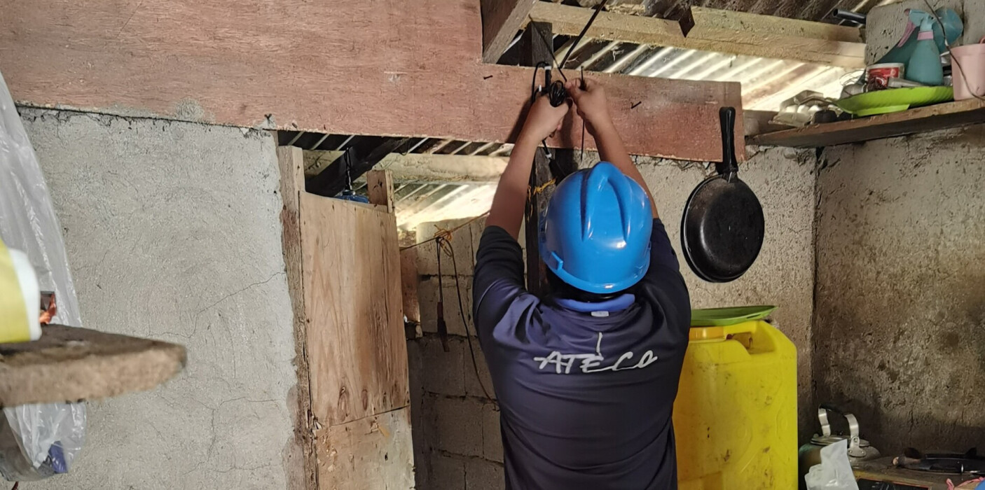 Un technicien d'ATECo aux Philippines installe un système d'éclairage solaire.