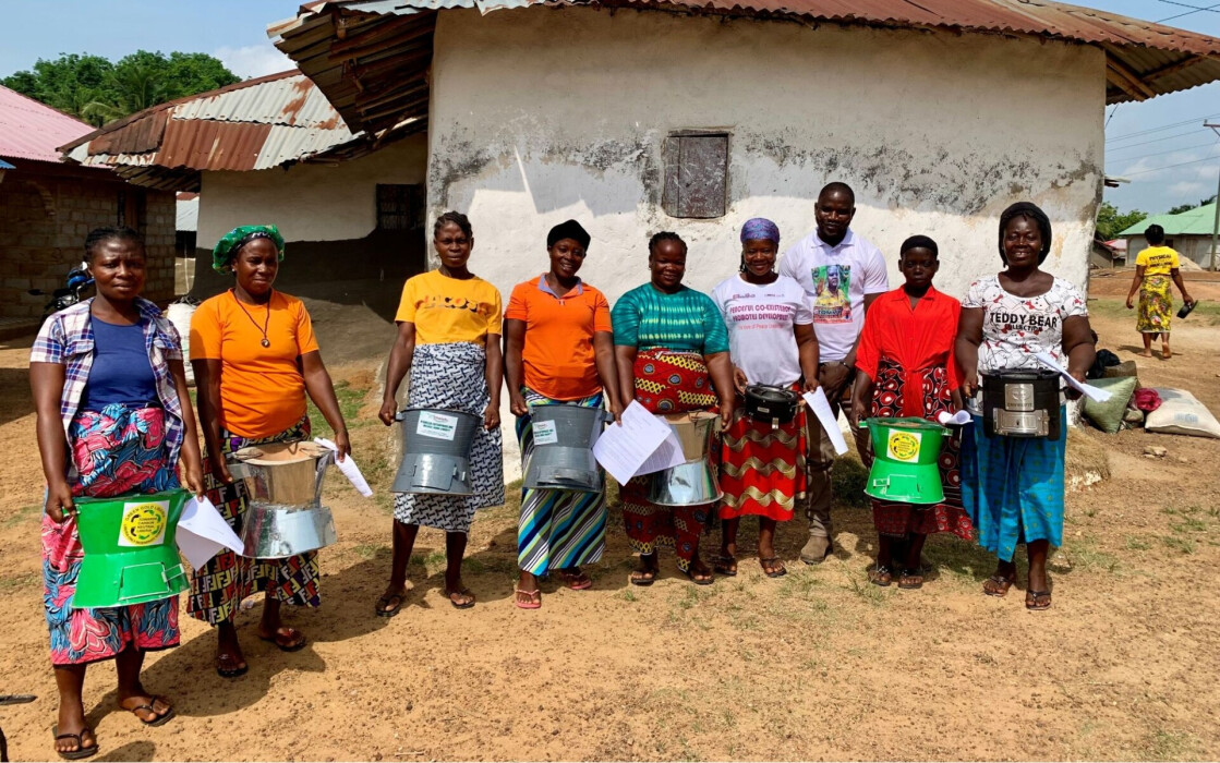 Un groupe de bénéficiaires d'Elili, au Libéria, montrent le réchaud de cuisson qu'elles vont tester
