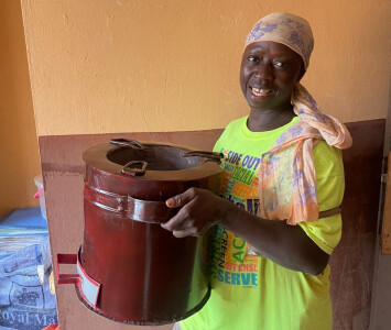 Une bénéficiaire de Munafa, en Sierra Leone, montre le réchaud de cuisson moderne qu'elle a acquis.