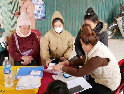 Des bénéficiaires d'Anh Chi Em au Vietnam déposent leur épargne auprès d'une animatrice.