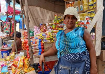 Une bénéficiaire de PMS en Haïti pose devant son stand au marché