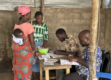 Une bénéficiaire d'Assilassimé au Togo dépose son épargne lors d'une réunion de groupe.