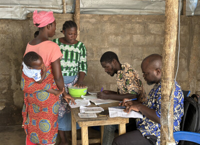 Une bénéficiaire d'Assilassimé au Togo dépose son épargne lors d'une réunion de groupe.
