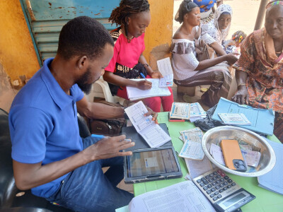 Un animateur de Yikri au Burkina Faso enregistre l'épargne déposée par un groupe de bénéficiaires.