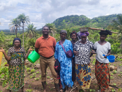 Le chargé de développement de Wakili et 5 agricultrices posent dans un champ
