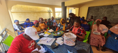 Les bénéficiaires de Wakili déposent leur épargne lors d'une réunion de groupe