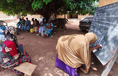 Groupe de bénéficiaires de Wakili en train de suivre une formation, une femme écrit sur un tableau 