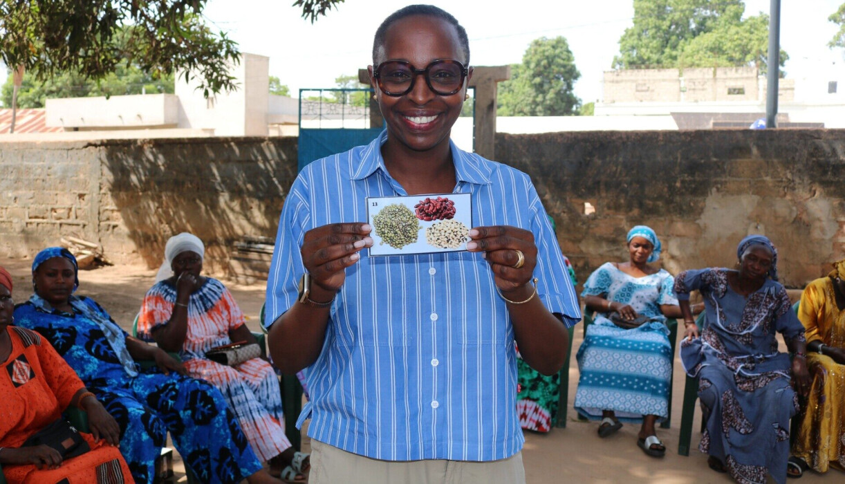 Khadi Desprez tient dans ses mains une carte avec des dessins de légumineuses, utilisée lors d'une 