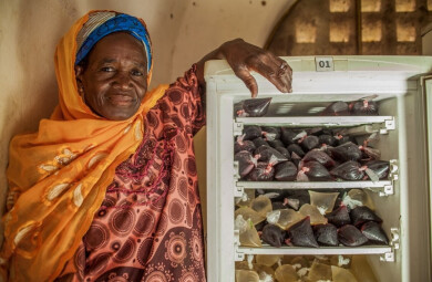 Une commerçante au Mali pose à côté d'un frigo rempli de boissons fraiches