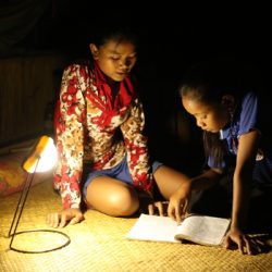 Des enfants travaillant éclairés avec une lampe distribuée par un programme énergie d'Entrepreneurs du Mondepe distribuée
