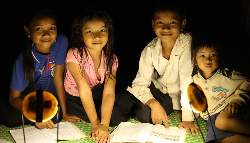 Enfants éclairés par une lampe solaire